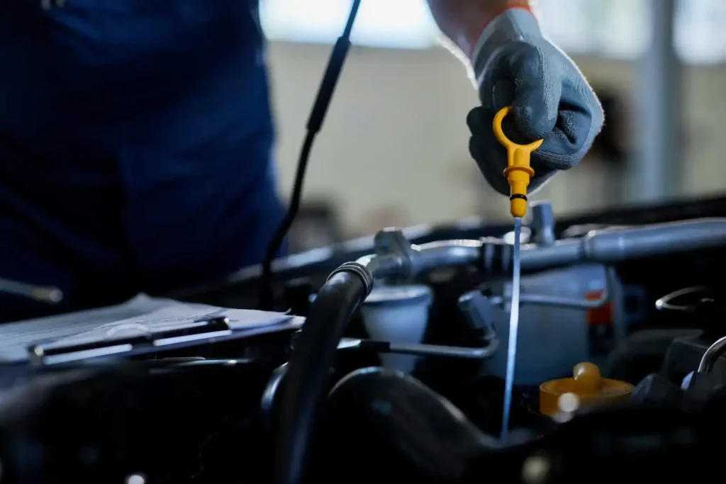 closeup of auto repairman checking car oil in workshop - Gonzalez MotorSport e-commerce