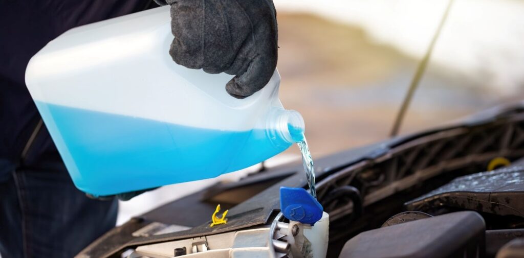man filling antifreeze coolant for cleaning front - Gonzalez MotorSport e-commerce